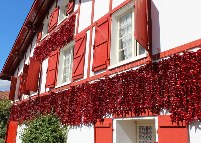 Piments en train de sécher sur la façade d'une maison à Espelette